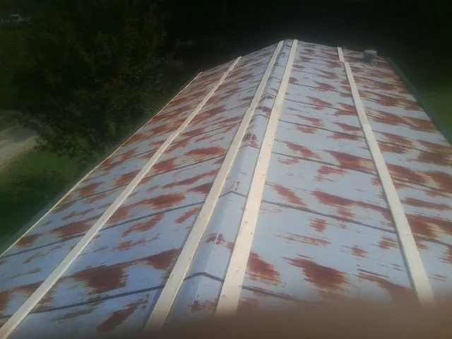 Rusted metal roof panels with new wood purlins before replacement — Storm Damage Roof Repair in Holderness by Roofing Brothers